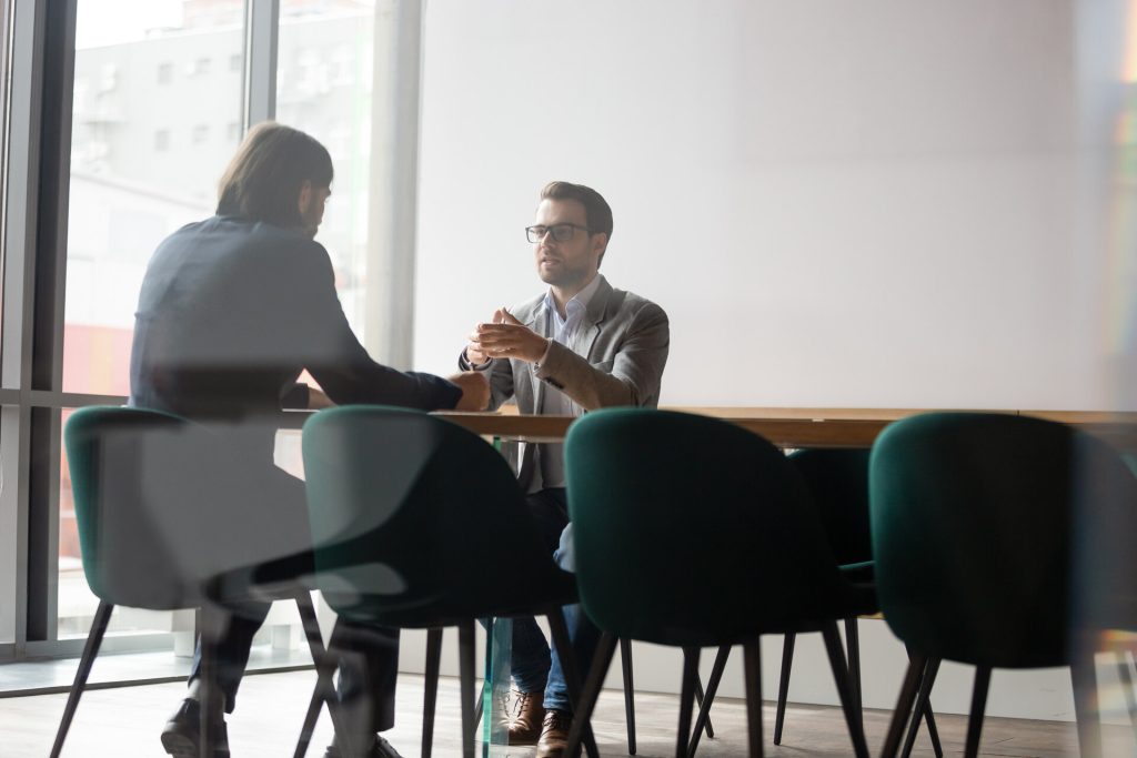 Dos hombres hablan en una sala de reuniones